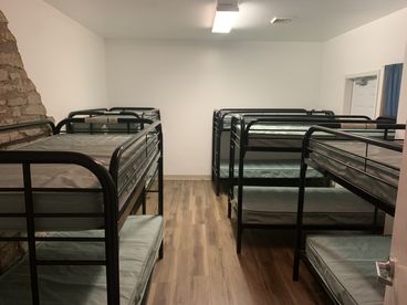 Bunk room with a stone wall