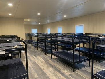 Long bunk room with rows of bunk beds